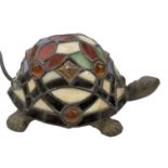 A Tiffany style bronzed metal tortoise lamp with coloured glass shade/shell, length 20cm. (af)