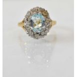 An 18ct yellow gold aquamarine and diamond set cluster ring, the central aquamarine approx 2ct and