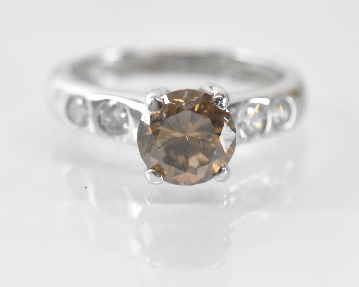 An 18ct white gold single stone diamond ring, the central round brilliant cut cognac coloured