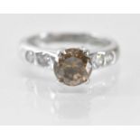 An 18ct white gold single stone diamond ring, the central round brilliant cut cognac coloured