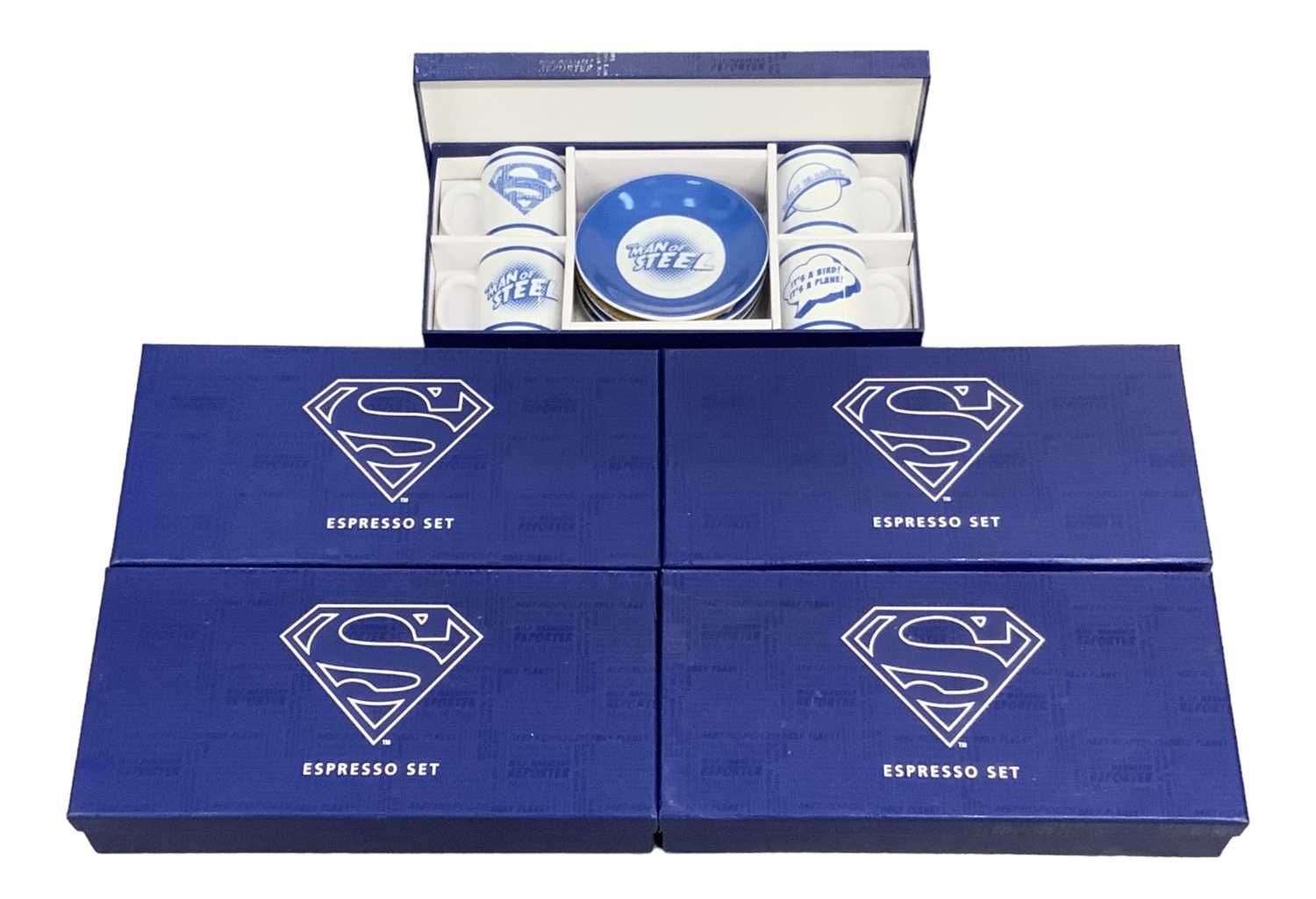 A group of five boxed Superman espresso sets, each comprising four coffee cups and saucers.