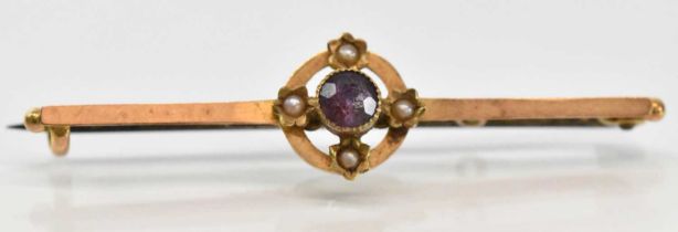 A 15ct yellow gold brooch set with central purple stone and four small seed pearls, length 4.5cm,