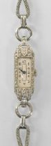 A 1930s Art Deco platinum and diamond set lady's wristwatch on white metal strap, the white enamel