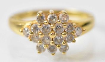 A yellow metal cluster ring set with sixteen small white stones, size M, approx 4.3g.