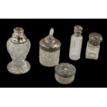 A group of four hallmarked silver topped scent bottles, one lacking stopper, height of tallest 12cm,