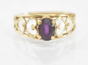 A 14ct yellow gold ring set with central purple stone, size M, approx 1.7g.