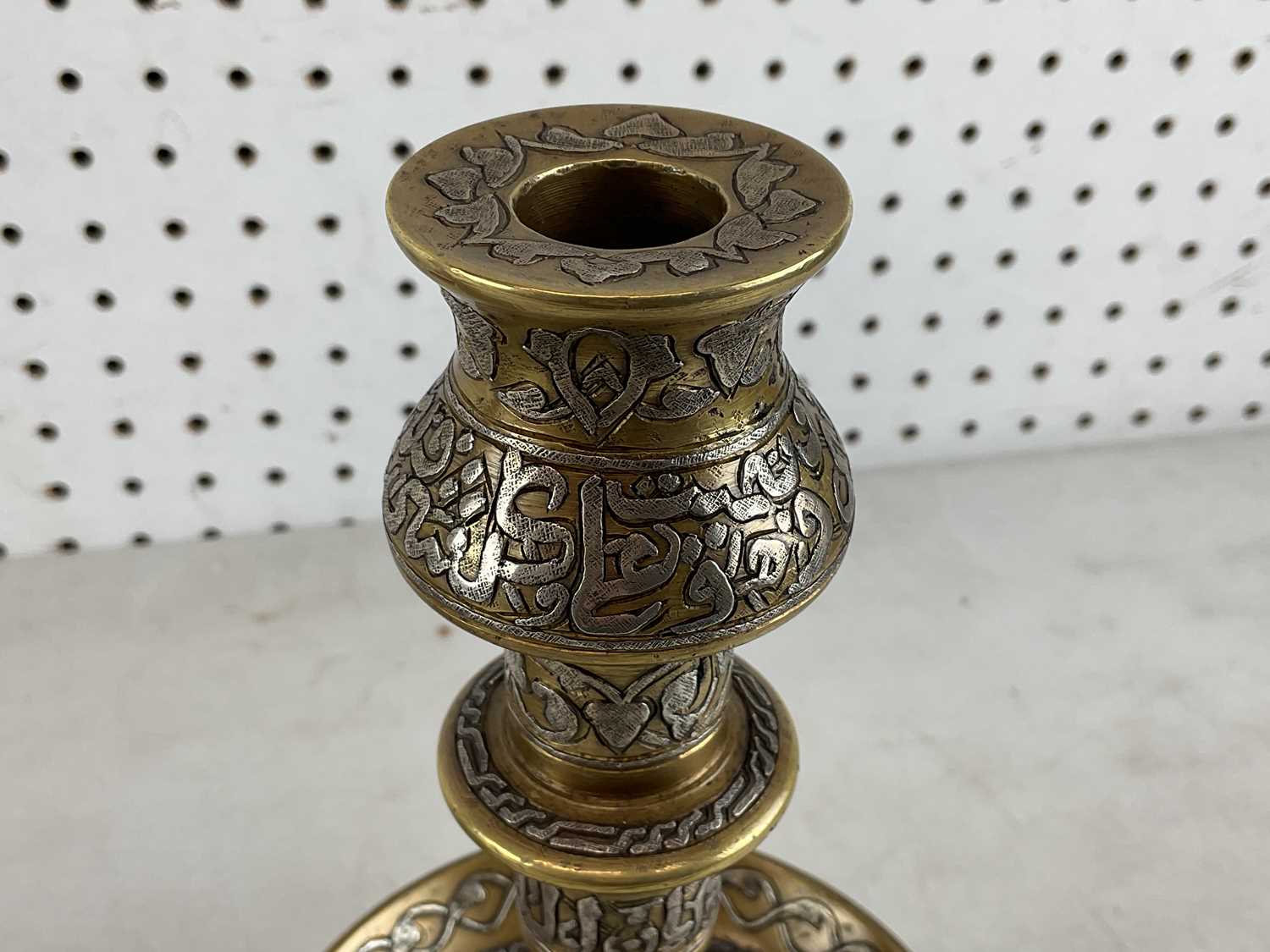 A pair of Islamic brass and silver inlaid candlesticks with Arabic calligraphy, height 30cm. - Image 3 of 3