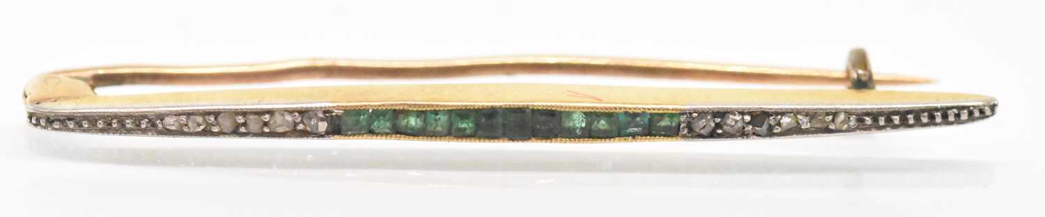A yellow metal emerald and diamond set bar brooch, with multiple square set emeralds flanked by