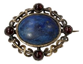 A yellow metal brooch set with central lapis lazuli and four surrounding red stones, 4 x 4.5cm,