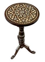 An Islamic tripod table inlaid with mother of pearl and bone, height 71cm, diameter 32cm.