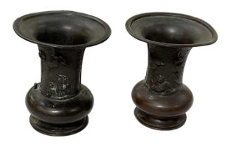 A pair of Japanese bronze Meiji period vases decorated with figures amongst foliage, six character