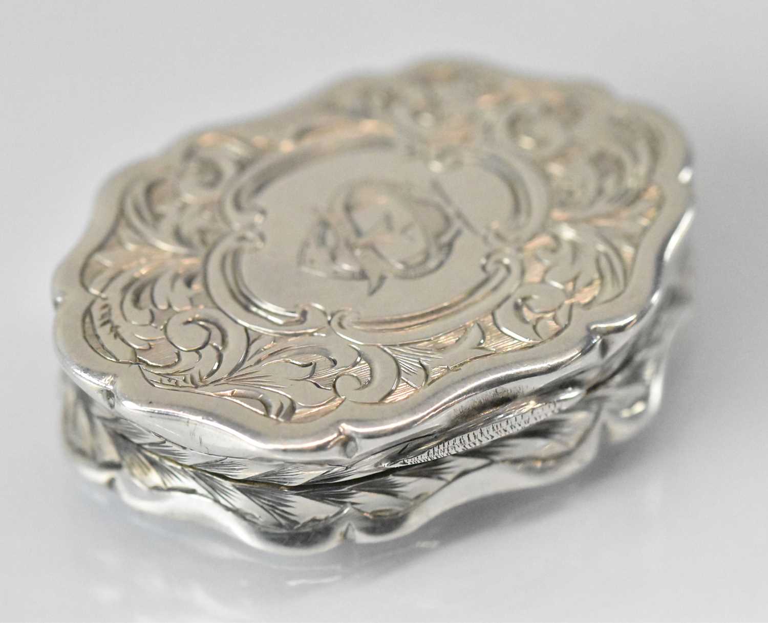 GEORGE UNITE; a Victorian hallmarked silver shaped oval vinaigrette with pierced gilt interior,