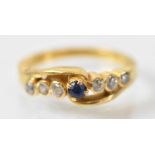 A yellow metal ring set with central blue stone flanked by six small white stones, size J/K,