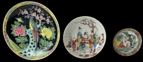 A modern Chinese black ground hand painted dish decorated with a peacock amongst foliage and with