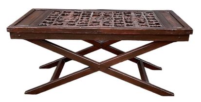 A heavily carved Chinese panel, mounted on a modern X-frame table base, top 166 x 73cm.