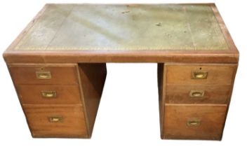 WARING & GILLOW; an early 20th century mahogany campaign style pedestal desk, with gilt tooled green
