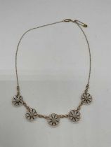A 9ct yellow gold necklace set with five flower heads, each centred with a cultured pearl, length