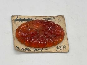 An unusual floral carved single carnelian oval plaque mounted on card, 38 x 25mm.