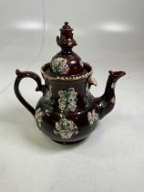 A 19th centuty bargeware teapot and cover with moulded floral and bird motifs (af).