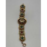 A yellow metal and enamelled bracelet consisting of one large and six small circular plaques, the