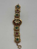 A yellow metal and enamelled bracelet consisting of one large and six small circular plaques, the