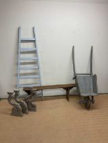 A collection of rustic wooden items including a French painted wheelbarrow, a painted French ladder,