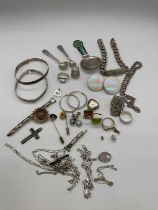 A group of silver and white metal, including an ID bracelet, chains, rings, an enamel caddy spoon (