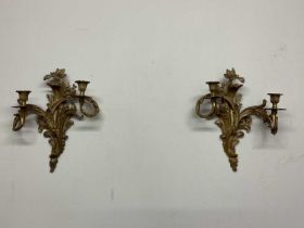 A pair of gilt brass two branch wall lights in Rococo form, with foliage cast sconces, height 35cm.
