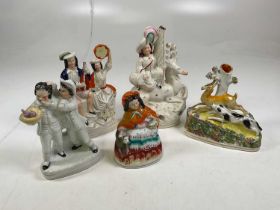 A collection of five Staffordshire ceramic flatback figures including a dog and deer.