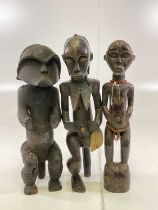 Three African carved wooden tribal figures, height 60cm (3).