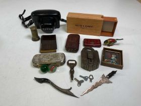 A group of collectors' items including a camera, trench art coin holder, toy wind-up bird, various