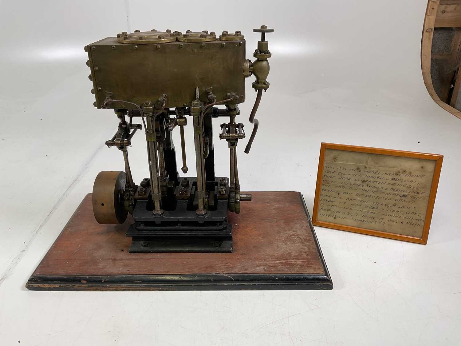 A scratch built scale model twin cylinder marine engine mounted on a wooden base, with