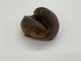 A contemporary Japanese boxwood netsuke modelled as two fish, signed, length 40mm.