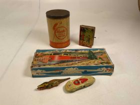 A collection of vintage clockwork toys and advertising tins including a Sharps Super-Kreem toffee