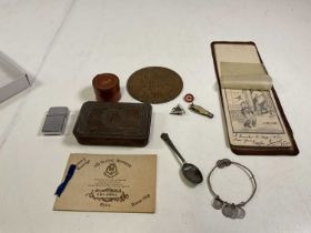 A small collection of WWI items including a remembrance plaque, a Christmas 1914 tin, trench art,