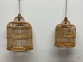A pair of vintage mid 20th century cane work bird cages converted into pendant lights, largest