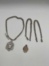 A graduated silver Albert chain with fob, two further short Albert chains and associated fob,