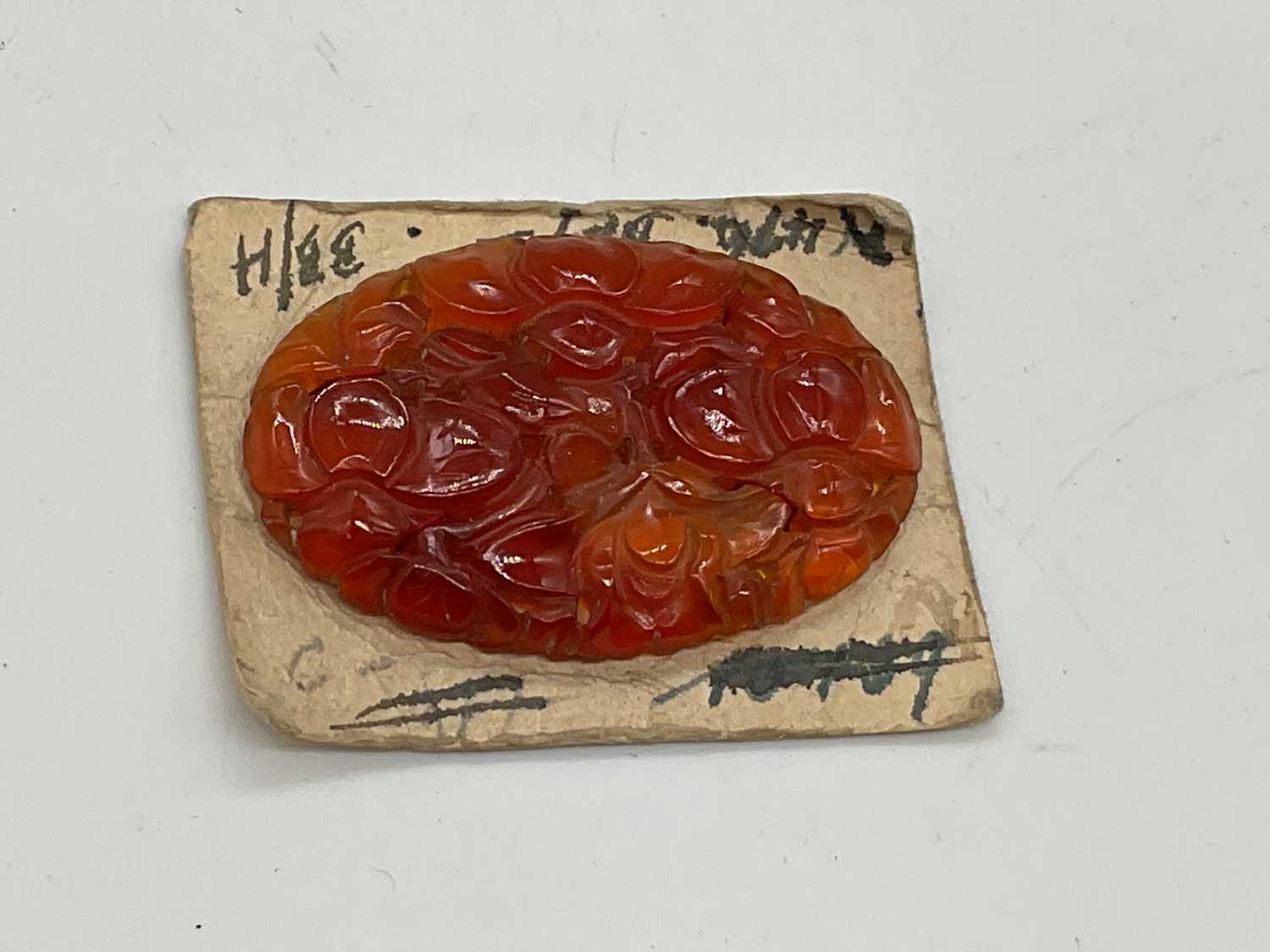 An unusual floral carved single carnelian oval plaque mounted on card, 38 x 25mm. - Image 2 of 2