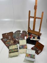 A quantity of artists' materials including painting boxes, palettes and an easel.