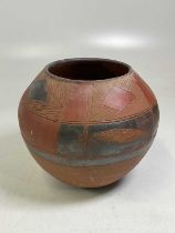 An African painted terracotta globular pot with encased detail, diameter 32cm.