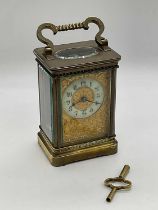 A French circa 1900 brass carriage clock with elborate floral engraved front plate, Arabic