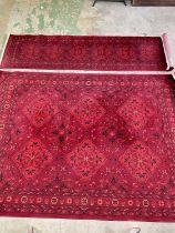 Two Afghan rugs, the rug 215 x 305cm, the runner 80 x 305cm.