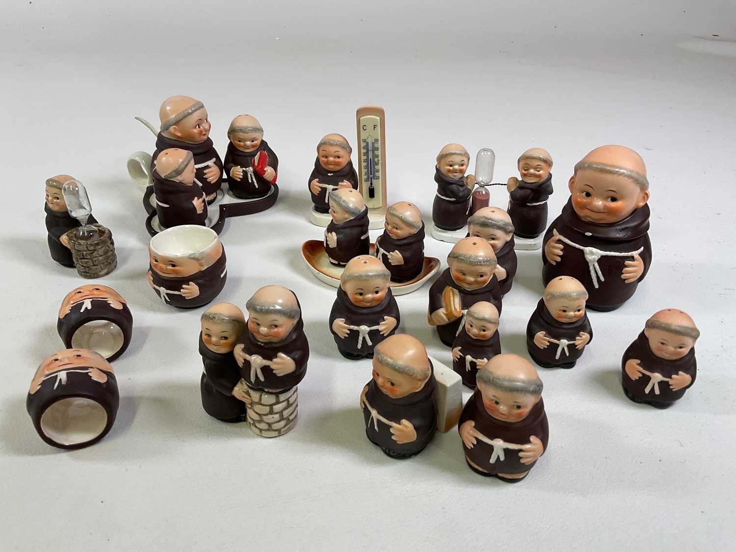 A collection of Goebel monks including a cruets, a timer, napkin rings, bottle stop, thermometer and