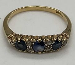 An 18ct yellow gold sapphire and diamond ring set with three sapphires and six tiny diamonds, size