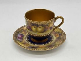 ROYAL WORCESTER; a fruit painted cup and saucer decorated with cherries and apples