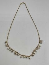 A delicate Edwardian yellow metal and seed pearl necklace, length approx 40.5cm.