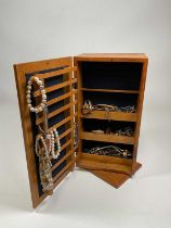 A collection of costume jewellery comprising necklaces, watches, and brooches, in a mirrored two