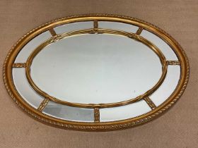 A contemporary decorative gilt oval wall mirror, 112 x 83cm.