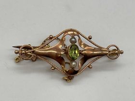 A 9ct rose gold peridot and seed pearl Art Nouveau pierced bar brooch, length 42mm, approx 2.7g.