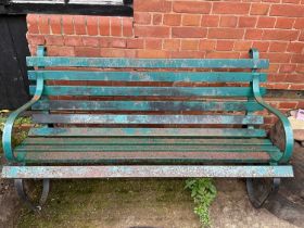 A green painted iron garden bench, width 155cm.